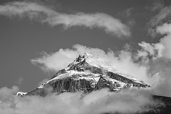 Dramatic Black and White Snowy Mountain Peak Through Clouds