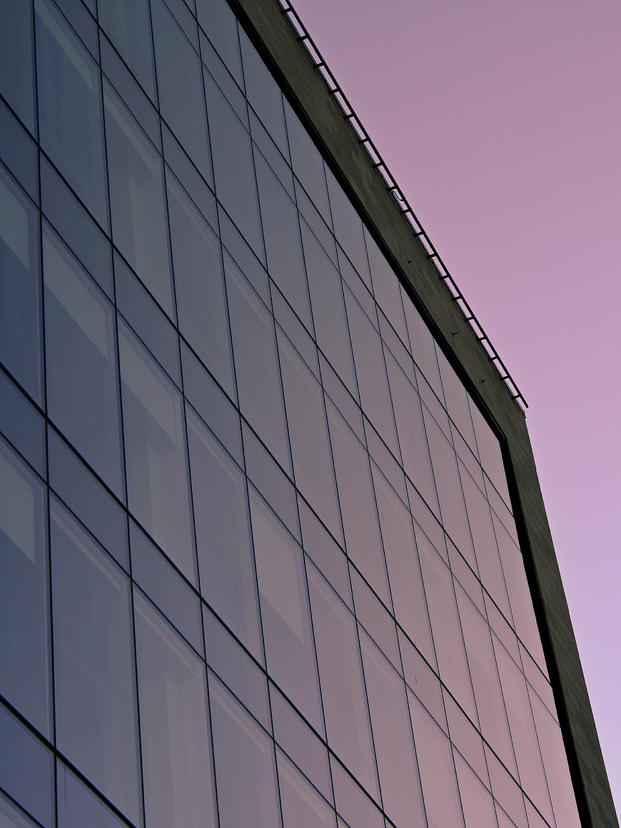 Modern Glass Office Building Facade Against Pink Sky