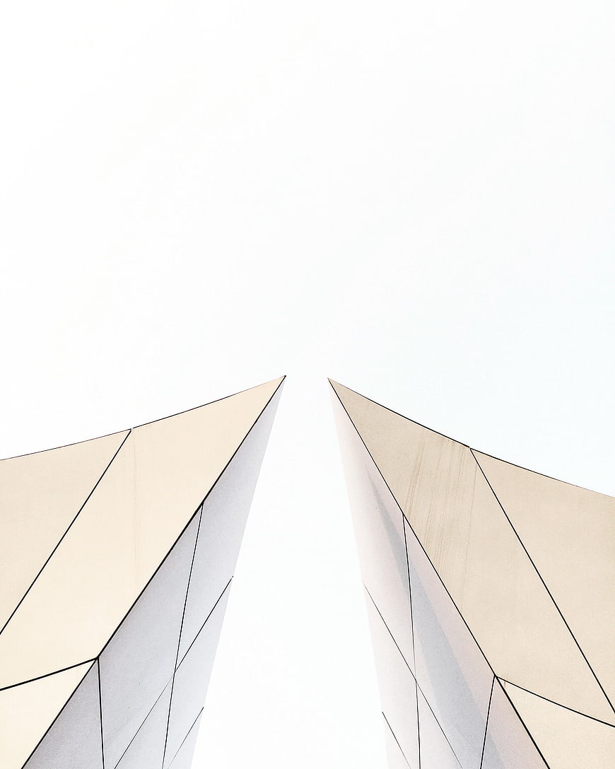 Minimalist architectural perspective of modern building peaks against white sky