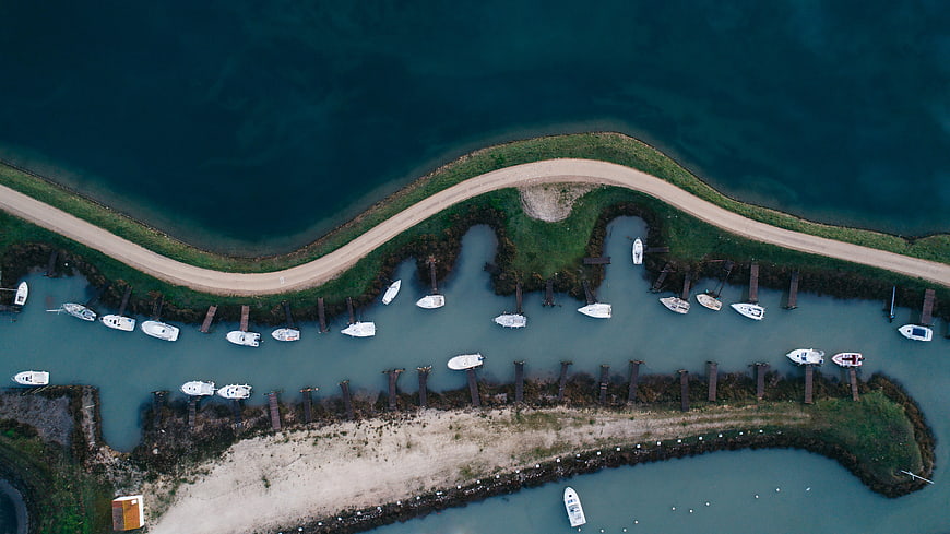 Aerial View of Curved Marina with White Boats