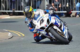 Motorcycle racer leaning into a turn on a race track