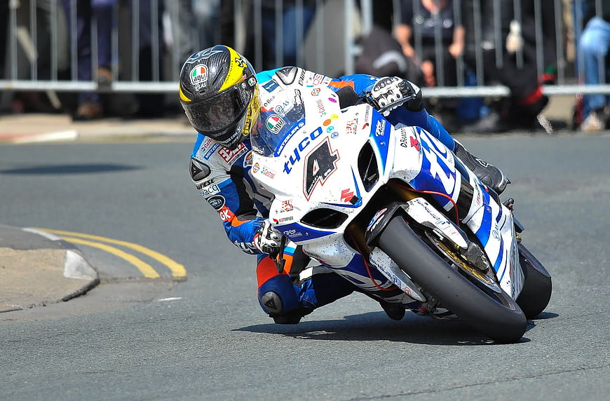Motorcycle racer leaning into a turn on a race track