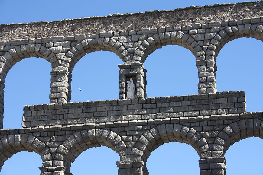 Ancient Roman amphitheater stone arches against blue sky