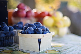 Fresh Blue Plums in Wooden Basket at Farmers Market