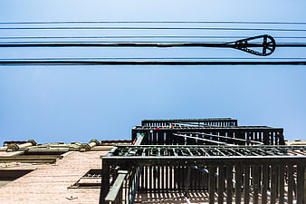 Urban rooftop architecture with power lines against blue sky