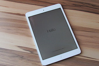 White iPad on wooden table with German setup screen