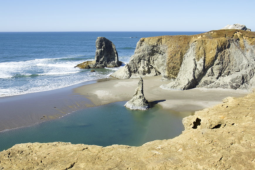 Scenic coastal cliffs and sea stacks on a sunny beach