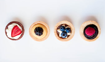 Top View of Four Mini Fruit Tarts on White Background