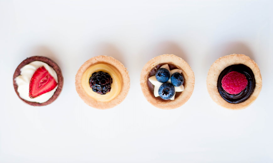 Top View of Four Mini Fruit Tarts on White Background