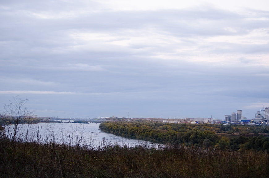 Wide river landscape with industrial city skyline and autumn foliage