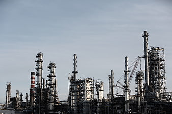Industrial Refinery Complex with Tall Chimneys Against Blue Sky