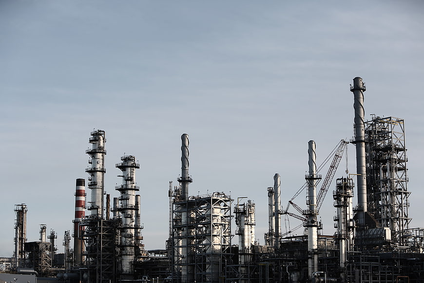 Industrial Refinery Complex with Tall Chimneys Against Blue Sky