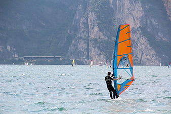 Windsurfer on Lake with Mountain Cliffs Background
