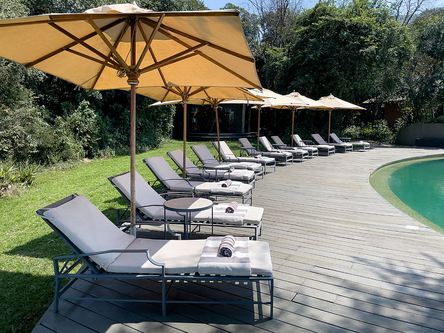 Luxury resort poolside with lounge chairs and umbrellas