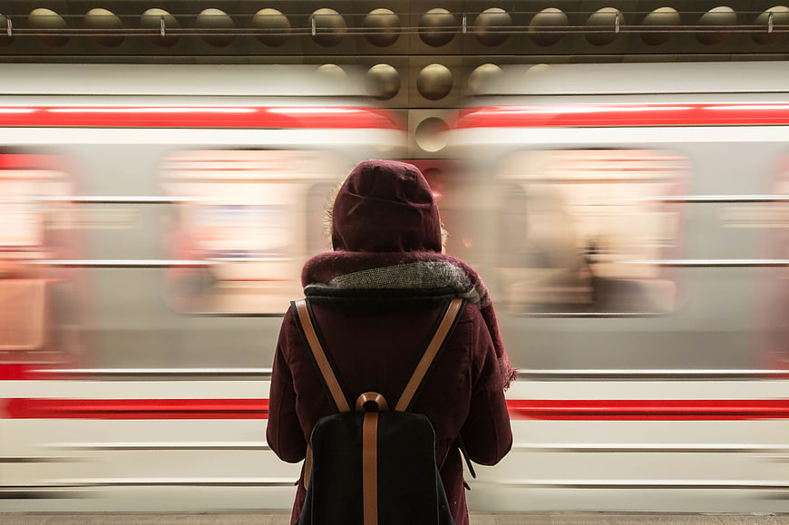 Person waiting for subway train with motion blur background