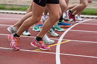 Runners' Legs and Shoes on Track Starting Line