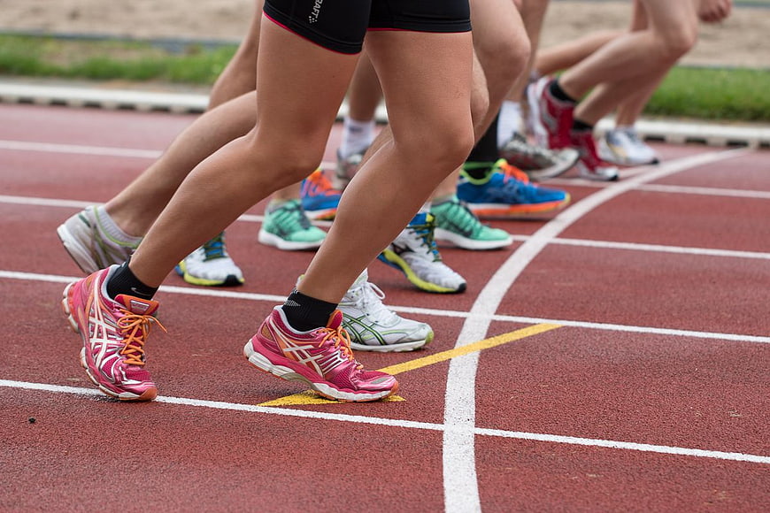Runners' Legs and Shoes on Track Starting Line