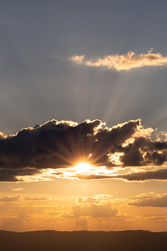 Dramatic Sun Rays Bursting Through Clouds Over Mountains