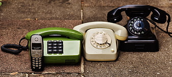 Vintage and Modern Telephones on Stone Pavement