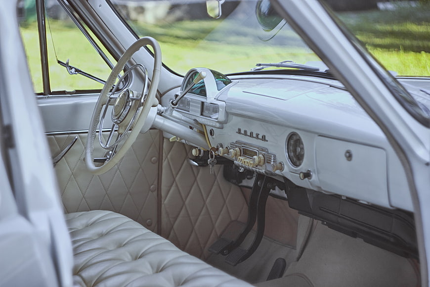 Vintage White Car Interior with Quilted Seats and Steering Wheel