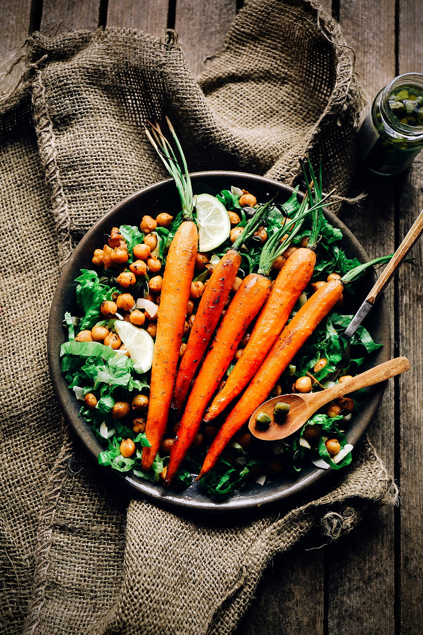 Overhead view of roasted carrots and chickpea salad on rustic wood