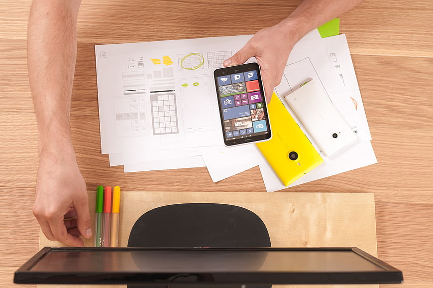 Top View of UX Designer Working on Smartphone Wireframes