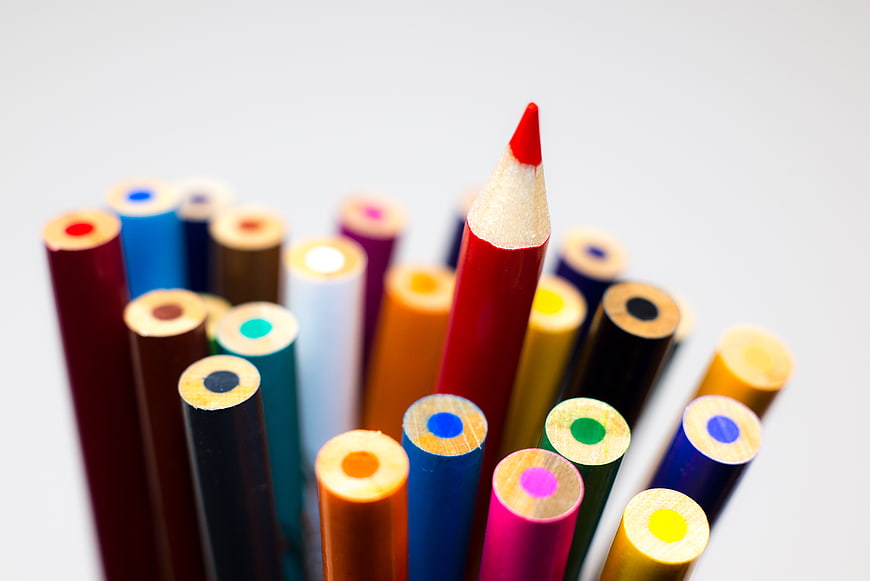 Sharp Red Pencil Standing Out Among Blurred Colored Pencils