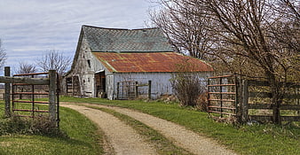 Rustic Old Farmhouse With Gravel Path And Rusty Metal Gates