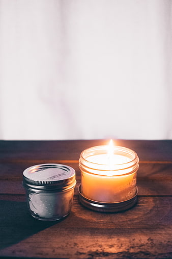 Lit Candle in Mason Jar on Wooden Table