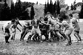Rugby scrum in muddy field black and white