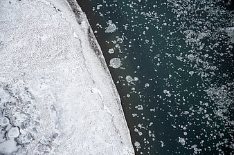 Aerial view of frozen sea ice and dark water