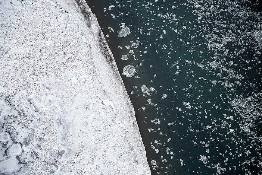 Aerial view of frozen sea ice and dark water