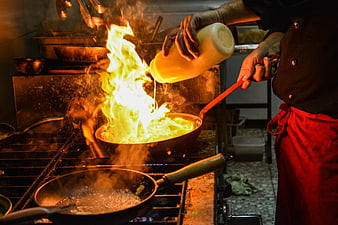 Chef Flambéing Food in Professional Kitchen