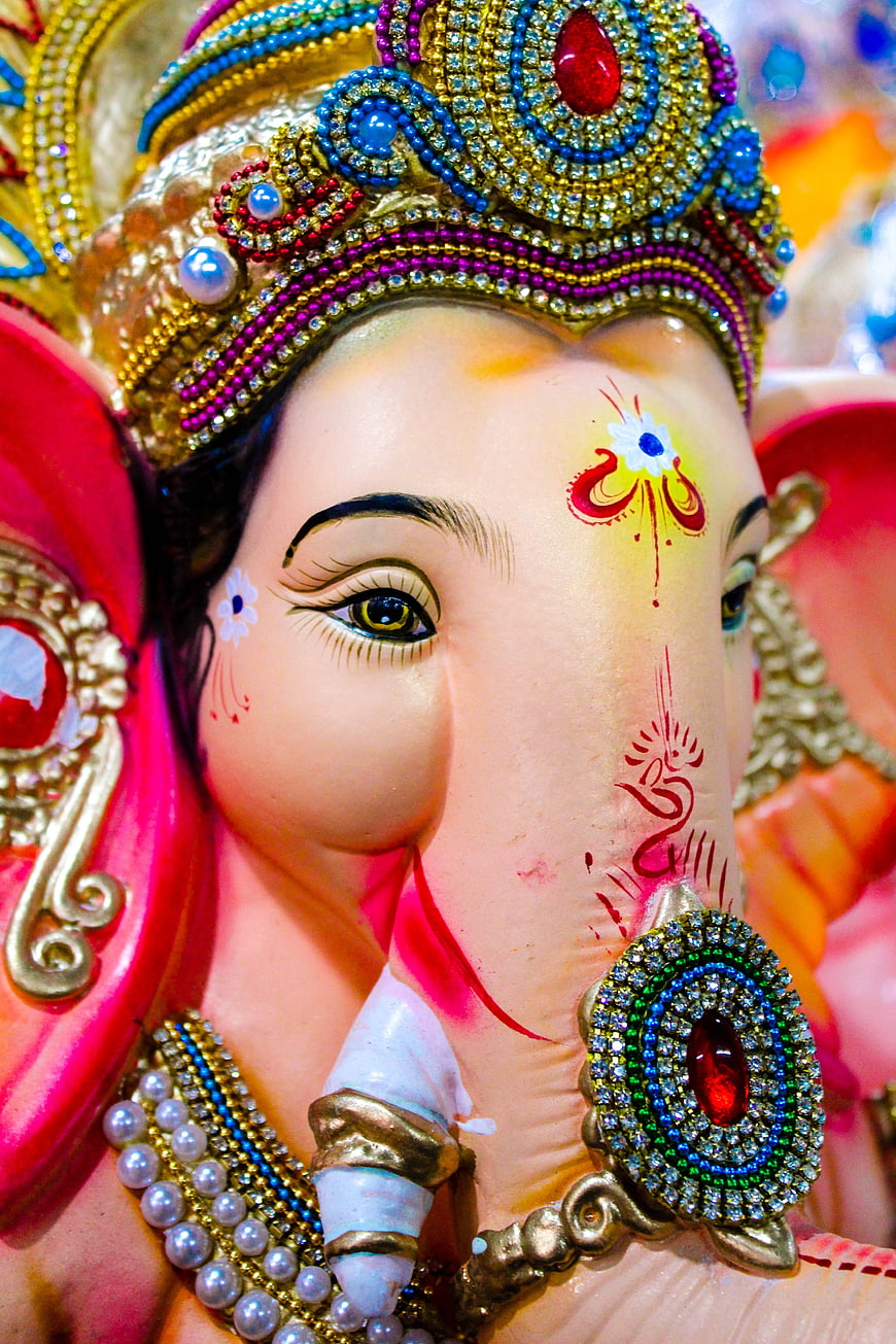 Close-up of ornate Lord Ganesha statue with vibrant jewelry