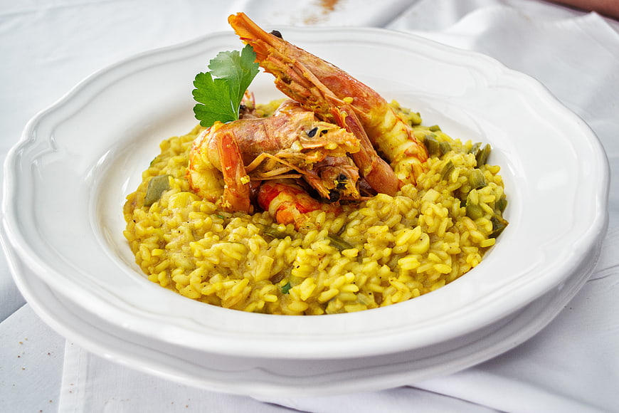 Yellow Shrimp Risotto with Prawns on White Plate