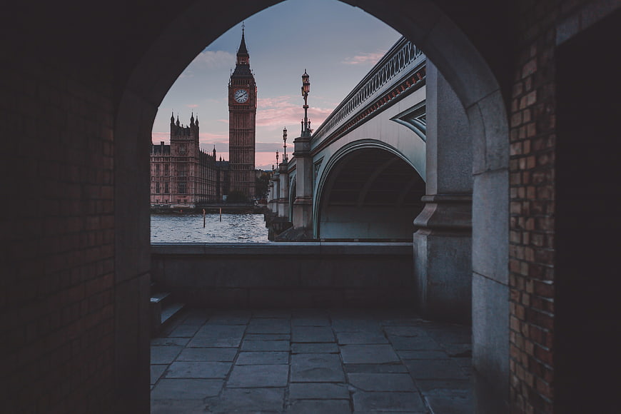 View of Big Ben and Westminster Bridge through a brick archway