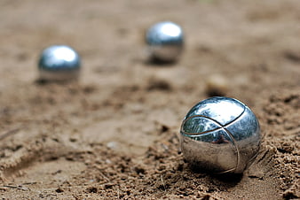 Close-up of Shiny Silver Metal Spheres on Sand