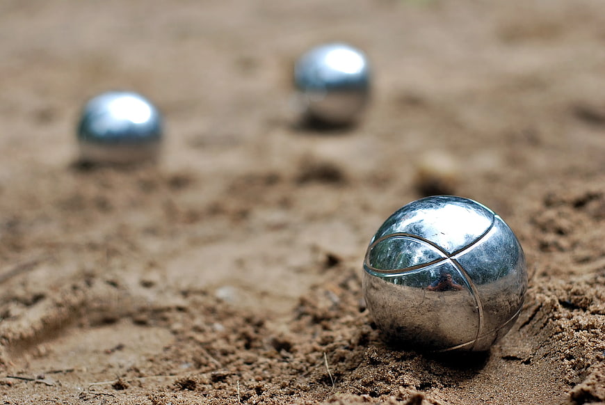 Close-up of Shiny Silver Metal Spheres on Sand