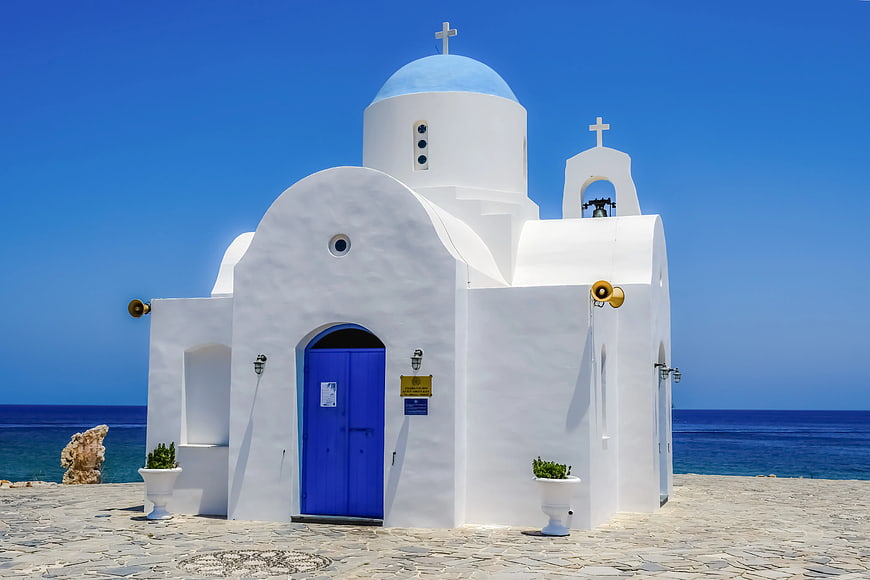 White Greek Orthodox Church with Blue Dome by the Sea