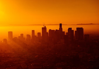 Dramatic orange sunset over Los Angeles skyline silhouette