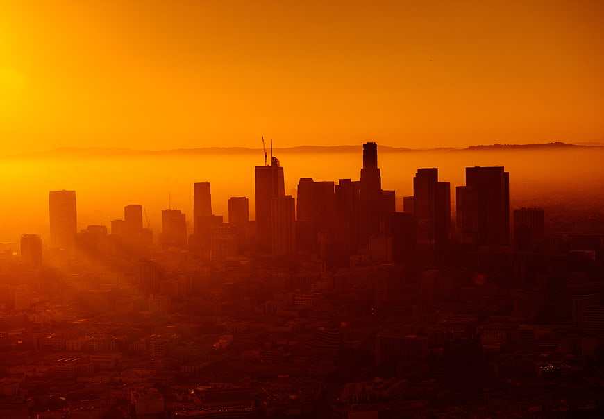 Dramatic orange sunset over Los Angeles skyline silhouette