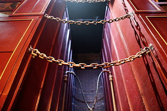 Red wooden doors secured with heavy metal chains