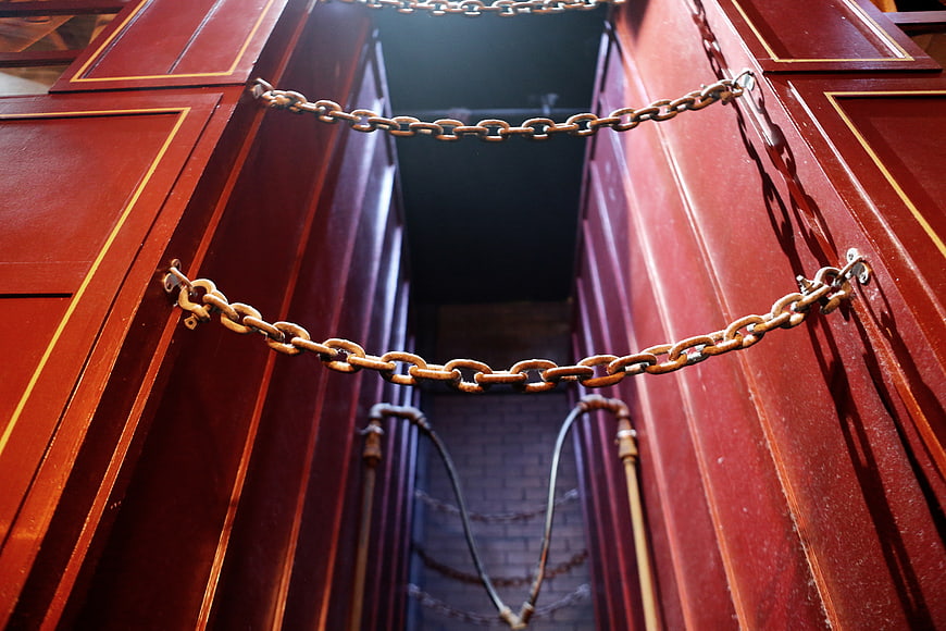 Red wooden doors secured with heavy metal chains