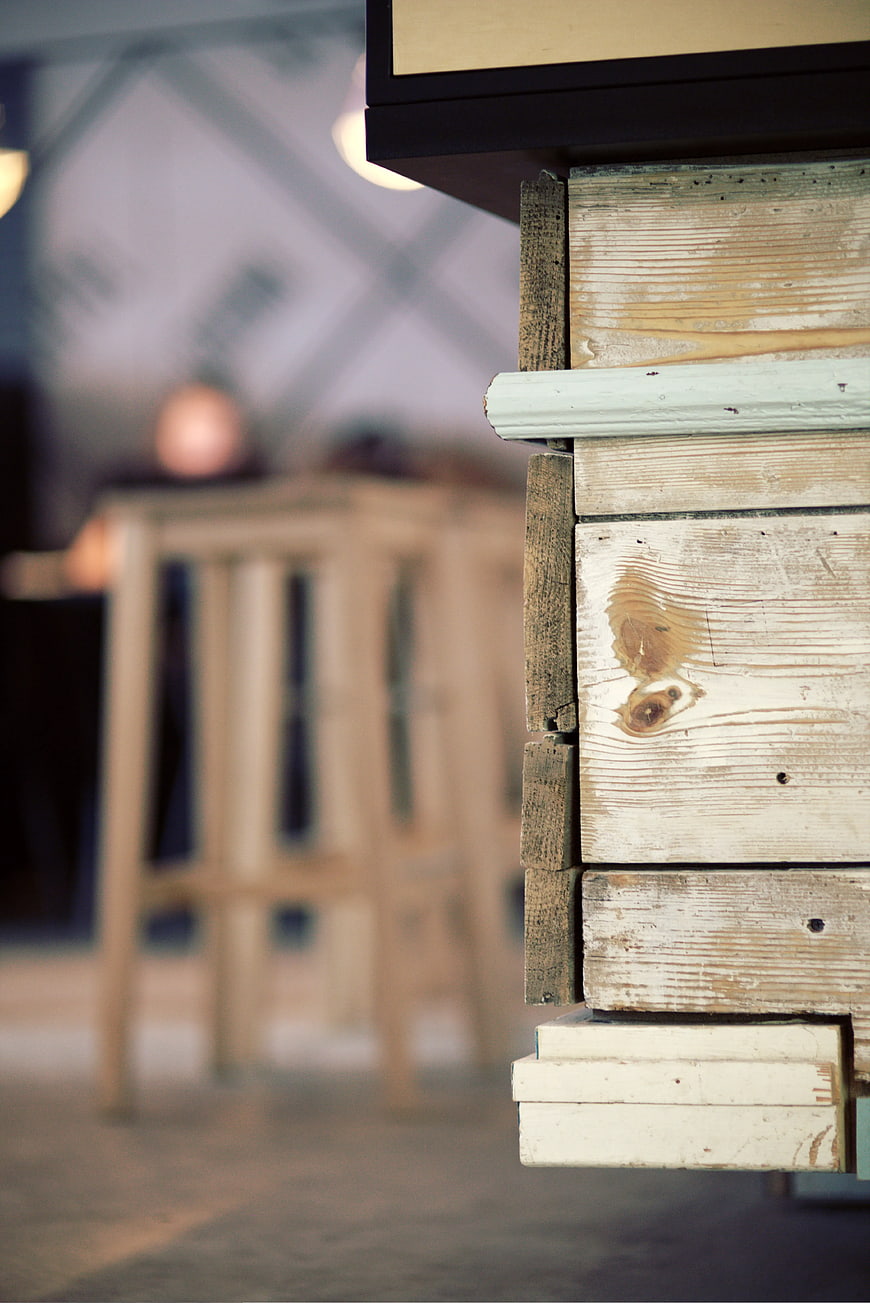 Close-up of rustic wooden furniture with blurred cafe background