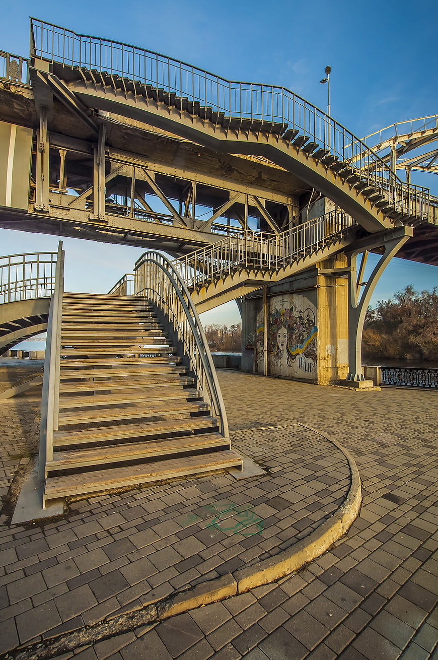 Urban wooden staircase under metal bridge structure