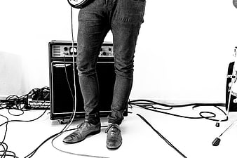 Musician legs with guitar amplifier and cables