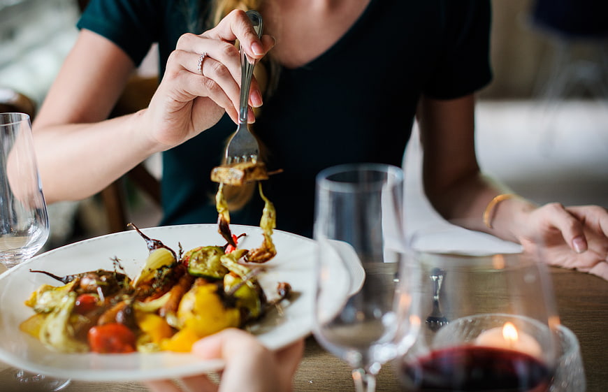 Woman Eating Grilled Vegetables with Red Wine