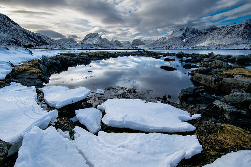 Snowy Arctic Landscape with Ice Pools and Mountain Reflections