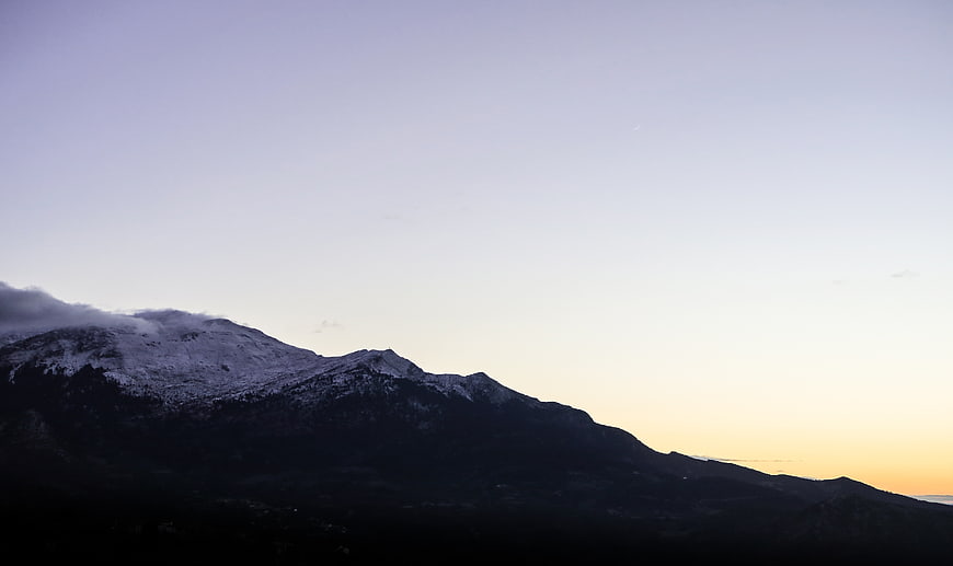 Snow-capped mountain silhouette against twilight sky
