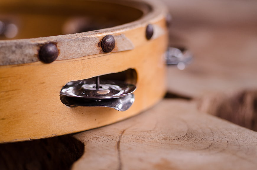 Close-up of a wooden tambourine with metal jingles and leather straps